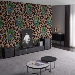 May include: A modern living room featuring a black entertainment center with a marble-like top, two round coffee tables, and a wall with a leopard print and peacock feather design. A framed artwork is displayed on the entertainment center.