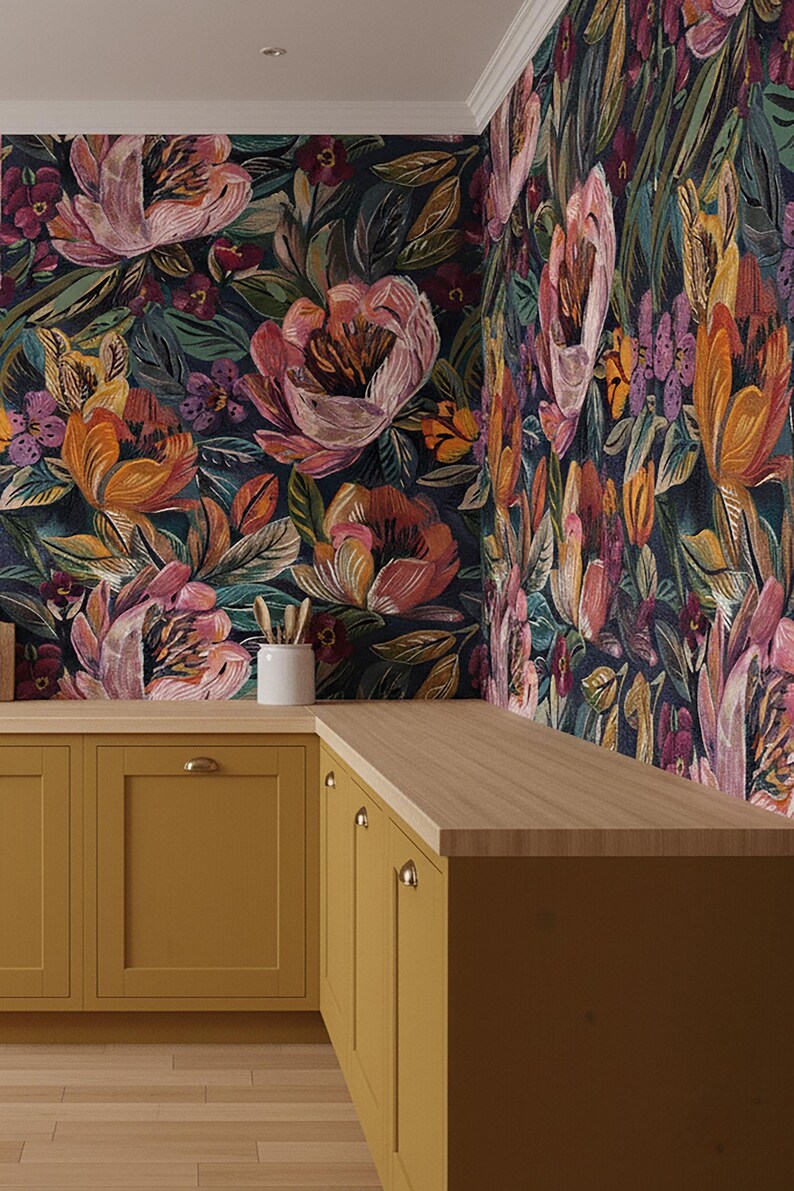 May include: A kitchen corner with mustard-yellow cabinets and gold handles, topped with a light wood work surface. The walls are decorated with dark floral wallpaper in pink, orange, and green, creating a colourful and stylish space.