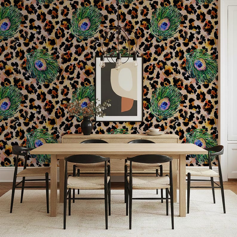 May include: A dining room featuring a light wood table and black chairs. The wallpaper has a leopard print pattern with peacock feather accents. A framed abstract art piece hangs on the wall, and a chandelier is above the table.