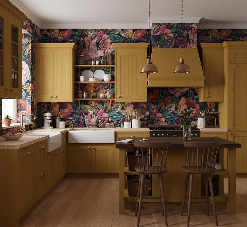 May include: A kitchen with mustard-yellow cabinets, a dark wood island, and floral wallpaper. The kitchen has a farmhouse sink, a range, and two pendant lights. Two wooden chairs are at the island.