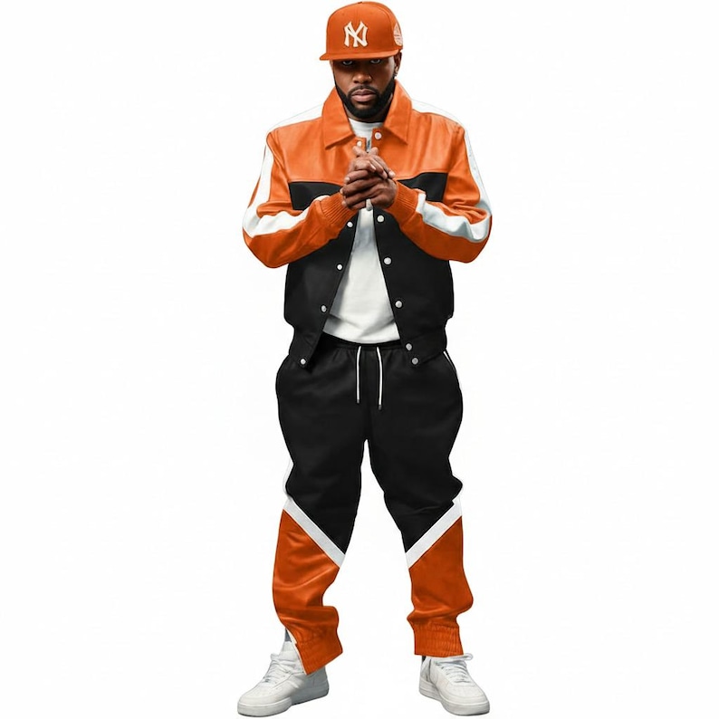 May include: A two-piece tracksuit in orange, black, and white. The jacket is orange with black and white accents, and the pants are black with orange and white details. A matching orange baseball cap completes the outfit.