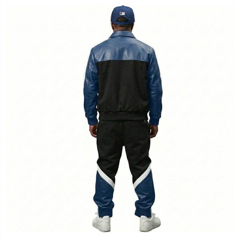 May include: A blue and black leather jacket and matching track pants set. The jacket has a blue upper section and black lower section. The track pants are black with blue and white accents. A blue baseball cap completes the outfit.
