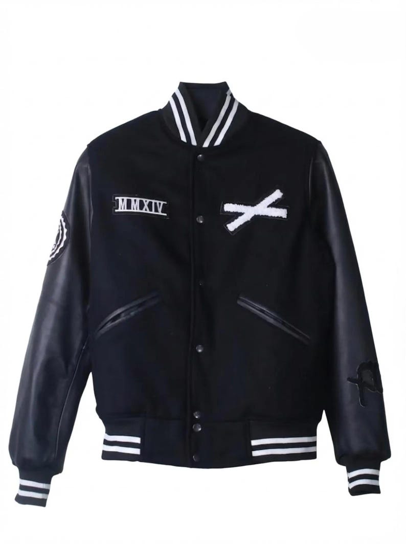 K&ouml;nnte beinhalten: Schwarze Collegejacke mit wei&szlig;en Akzenten. Sie hat schwarze Leder&auml;rmel, einen wei&szlig;en Kragen und wei&szlig; gestreifte S&auml;ume und B&uuml;ndchen. Enth&auml;lt die r&ouml;mische Zahl "MMXIV" und ein wei&szlig;es "X"-Design auf der Brust.