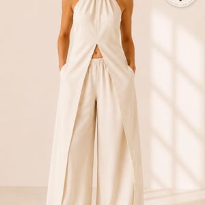 May include: A cream-colored halter-neck top with a front slit and matching wide-leg trousers. The top features a high neckline and the trousers have an elastic waistband. A label reads LearnSewingHub and a size range badge displays 00-32.