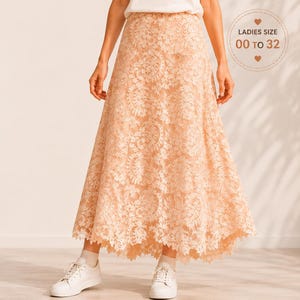 Puede incluir: Una falda larga de encaje color melocotón con dobladillo festoneado, combinada con una camiseta blanca lisa, calcetines blancos y zapatillas blancas. La imagen incluye el texto LearnSewingHub y una insignia circular que dice LADIES SIZE 00 TO 32.