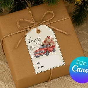 May include: A wrapped gift in brown paper tied with twine, featuring a tag with a red truck carrying presents. The tag reads "Merry Christmas" and has space for "To" and "From" details. The image also includes a blue and purple "Edit in Canva" button.
