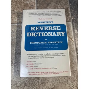 Puede incluir: Un libro titulado "Bernstein's Reverse Dictionary" de Theodore M. Bernstein. La portada blanca presenta un recuadro azul con el título. El texto explica el método del diccionario para encontrar palabras a través de sus significados.
