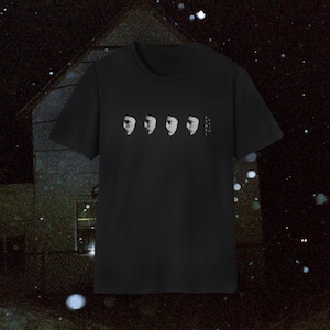 Peut inclure: Un t-shirt noir à manches courtes avec une impression graphique représentant quatre silhouettes blanches répétées d'un visage de profil. À droite des visages, le texte ETHEL CAIN est imprimé verticalement dans une police sans empattement.