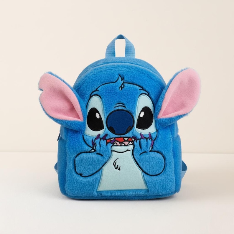 Puede incluir: Una mochila de felpa azul que representa al personaje Stitch de Lilo & Stitch. La mochila tiene orejas grandes con forro rosa, ojos grandes negros y una boca cosida. Tiene un asa superior peque&ntilde;a y correas ajustables.