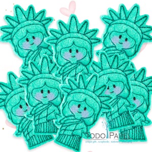 以下が含まれることがあります： 自由の女神の形をしたフェルトのアップリケ9個セット。各アップリケはターコイズブルーで、白い顔と黒い目があります。アップリケはクラフトプロジェクトに最適です。