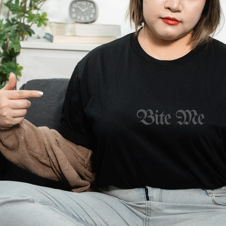 Unisex black Bite Me graphic shirt worn casually, subtle gothic typography dark aesthetic outfit