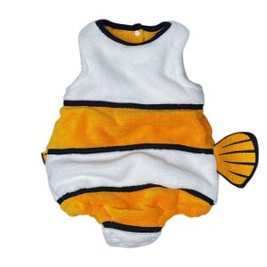 Può includere: Un costume per animali domestici a tema pesce bianco, arancione e nero. Il costume ha un top bianco con finiture nere e interno giallo. Il corpo è bianco e arancione con strisce nere. Una pinna gialla e nera è attaccata sul retro.