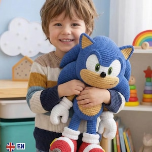 Puede incluir: Un niño sostiene un gran peluche azul de Sonic the Hedgehog tejido a ganchillo. El juguete tiene guantes blancos, zapatos rojos y blancos y detalles amarillos. Las palabras "PDF PATTERN" son visibles en la esquina superior izquierda.