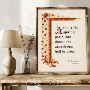 May include: A framed print with a quote, featuring ornate red and gold floral border designs. The text reads "Acquire the spirit of peace, and thousands around you will be saved." The print is displayed on a wooden table with a lamp and vase.