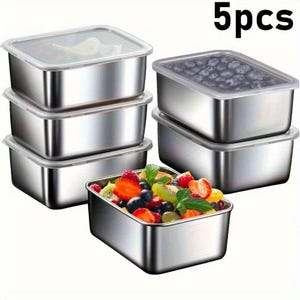 以下が含まれることがあります： 透明な蓋が付いた、ステンレス製の食品保存容器5個セット。1つの容器にはカラフルなフルーツサラダが入っています。容器は長方形で、積み重ね可能です。