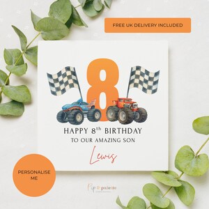 May include: A white birthday card with an orange number 8 and two monster trucks. The card reads "HAPPY 8th BIRTHDAY TO OUR AMAZING SON" with the name "Lewis" in cursive. Checkered flags are on either side of the number 8.