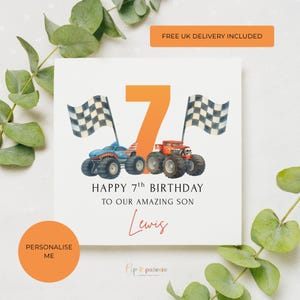 May include: A white birthday card with an orange number 7 and two monster trucks. The card reads "HAPPY 7th BIRTHDAY TO OUR AMAZING SON Lewis". Two checkered flags are on either side of the number.