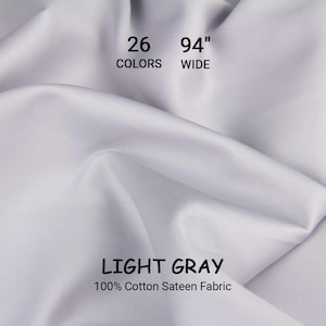 May include: Light gray 100% cotton sateen fabric, 94 inches wide. The image shows a close-up of the fabric with visible folds and the text "26 COLORS" and "LIGHT GRAY". This fabric is suitable for various sewing projects.