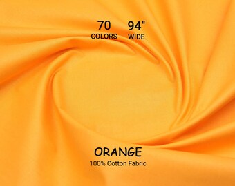 Op de afbeelding: Oranje 100% katoenen stof, 239 cm breed, met de tekst "ORANGE" en "100% Cotton Fabric". De afbeelding bevat ook de tekst "70 COLORS". De stof is effen oranje van kleur, met zachte plooien en een gladde textuur.