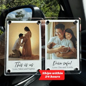 May include: Two clear acrylic photo displays, each featuring a family photo. One shows a pregnant couple, the other a couple with a newborn. Text on the displays reads "This is us" and "Drive safe!" with names below.