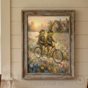 Puede incluir: Impresión digital enmarcada que muestra dos ranas antropomórficas en bicicleta tándem, vestidas con ropa vintage. El fondo presenta una casa y una puesta de sol. El marco es de madera envejecida. La obra se titula 'Digital Wall Art'.