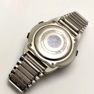 Puede incluir: Un reloj digital plateado con una correa de acero inoxidable, visto desde atr&aacute;s. La esfera del reloj es redonda y tiene las palabras "Water Resistant" y "Stainless Steel Back" impresas. La correa est&aacute; hecha de eslabones met&aacute;licos.