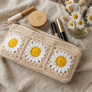 Boho cottagecore crochet zipper bag with puff flower granny squares, rectangular makeup pouch handmade using cream, white, and yellow cotton yarn.