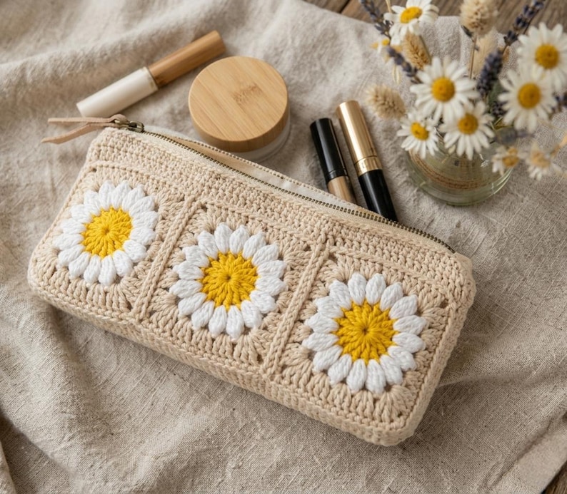 Boho cottagecore crochet zipper bag with puff flower granny squares, rectangular makeup pouch handmade using cream, white, and yellow cotton yarn.