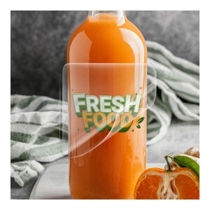 May include: A clear glass bottle filled with orange liquid, with a transparent label that reads "FRESH FOOD" in green and orange. A halved orange and a green and white striped cloth are in the background.