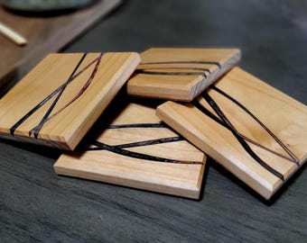Elegant wave design coaster made from black, bronze, and silver epoxy and alder wood