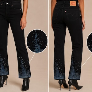 Può includere: Jeans in denim nero a vita alta con taglio a gamba dritta. La parte inferiore delle gambe è decorata con un motivo di strass blu che ricorda un disegno floreale o a fiamma. Un'etichetta del marchio in pelle beige è visibile sul retro.