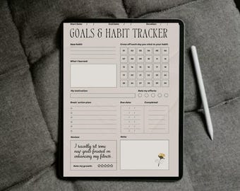 May include: A digital tablet displaying a "GOALS & HABIT TRACKER" template. The tracker includes sections for new habits, daily check-off boxes, and goal planning. A white stylus rests beside the tablet on a gray, textured surface.