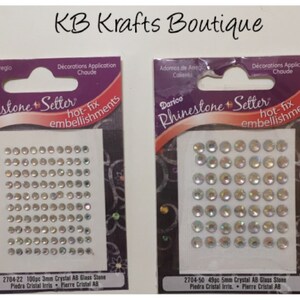 May include: Two packages of Darice Rhinestone Setter hot-fix embellishments. One package contains 100 pieces of 3mm Crystal AB Glass Stone, and the other contains 49 pieces of 5mm Crystal AB Glass Stone. The packages have a purple and white design with text.