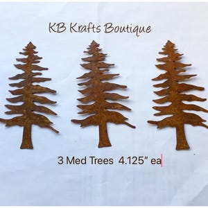 May include: Three rusty metal pine tree silhouettes, each measuring 4.125 inches tall. The trees are arranged in a row on a white background. The text "KB Krafts Boutique" and "3 Med Trees 4.125" ea" is visible below the trees.