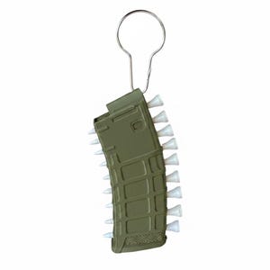 May include: An olive green rifle magazine shaped keyring featuring a series of small white golf tees inserted along the side edges. The object is attached to a silver metal split ring at the top, designed for holding keys or other small items.