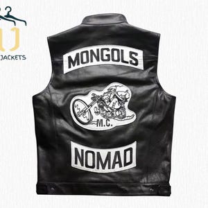 Könnte beinhalten: Schwarze Lederweste mit weißen Aufnähern. Die Aufnäher zeigen oben das Wort "MONGOLS", in der Mitte eine Motorradgrafik und unten das Wort "NOMAD". Die Weste hat einen Knopfverschluss am unteren Rand.