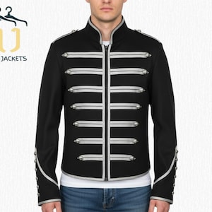 Könnte beinhalten: Schwarze Jacke im Militärstil mit silbernen Verzierungen und Akzenten. Die Jacke hat einen hohen Kragen, horizontale silberne Streifen und dekorative Knöpfe. Die Ärmel haben silberne Details. Der Markenname "NOIR JACKETS" ist sichtbar.