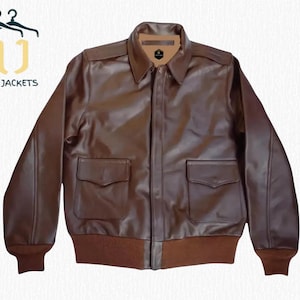 May include: A brown leather jacket with a collared neckline, two front pockets, and a ribbed hem and cuffs. The jacket has a zipper closure and is labeled "NOIR JACKETS".