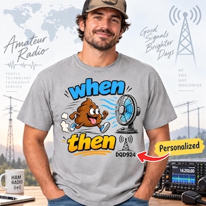 Può includere: Una t-shirt grigia con un personaggio a forma di escremento marrone in stile cartoon che corre verso un ventilatore elettrico blu. Il testo recita when then DQD924. Il design include un'icona di torre radio e linee di movimento blu.
