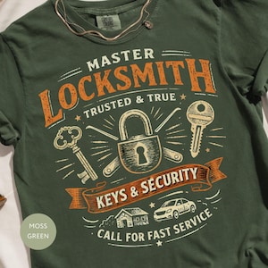 以下が含まれることがあります： モスグリーンのTシャツで、MASTER LOCKSMITH TRUSTED & TRUE KEYS & SECURITY CALL FOR FAST SERVICEという文字がプリントされています。デザインには中央の南京錠、2本の鍵、小さな家のアイコン、車のイラストが含まれています。