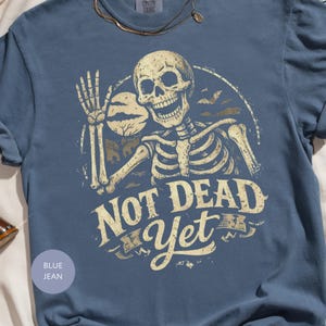 Not Dead Yet Skeleton Shirt, Funny Halloween Skeleton Tee, Spooky Goth Skull Graphic T-Shirt, Sarcastic Grim Reaper Gift
Not Dead Yet Shirt