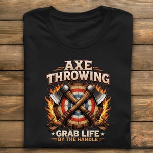May include: Black t-shirt featuring a graphic of two crossed axes in front of a target, surrounded by flames. The text "AXE THROWING" is above the target, and "GRAB LIFE BY THE HANDLE" is below.