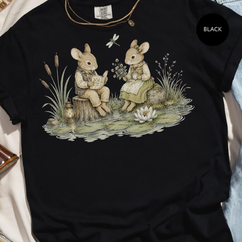 Watercolor illustration of two mice reading and drinking tea by a pond with a dragonfly.