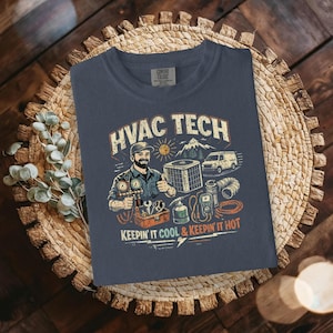 May include: Navy blue t-shirt with a graphic featuring an HVAC technician, tools, and the text "HVAC TECH KEEPING IT COOL & KEEPING IT HOT." The design includes a mountain, sun, and a van.