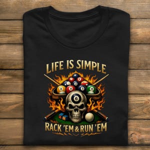 May include: Black t-shirt featuring a skull with a pool ball in its eye socket, surrounded by flames and pool balls. The text "LIFE IS SIMPLE" and "RACK 'EM & RUN 'EM" are printed above and below the graphic.