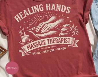Puede incluir: Camiseta de color carmesí con las palabras "Healing Hands" y "Massage Therapist" en blanco. El diseño incluye manos, una vela, piedras y las palabras "Relax, Restore, Renew". Se ve un collar dorado en la parte superior.