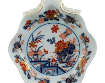 Plato de porcelana vintage Vista Alegre, diseño Imari, detalles dorados, asa integrada en forma de concha de vieira.