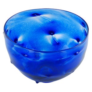May include: A round, blue glass bowl with a textured, rippled surface. The bowl has a deep, vibrant blue color with lighter blue and white swirls. The design includes several small, dark blue indentations, adding a unique visual element to the piece.