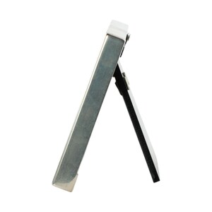 May include: A small, silver-colored picture frame with a hinged easel back. The frame is rectangular and has a simple, modern design. The back of the frame is black.