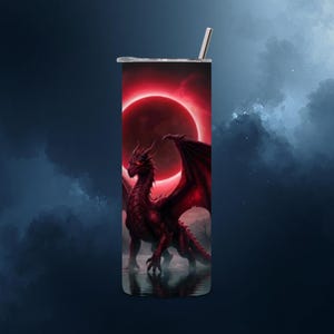 May include: A stainless steel tumbler featuring a red dragon with a red eclipse background. The dragon has red eyes and wings. The tumbler has a silver straw and lid. The design is a fantasy theme.